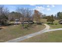 Aerial view of a home with large grounds and a gravel driveway surrounded by mature trees at 71 Romans Rd, Roxboro, NC 27574