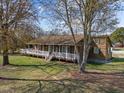 Inviting home with a spacious front porch and beautifully maintained landscaping, framed by mature trees at 71 Romans Rd, Roxboro, NC 27574