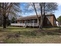 Charming home with a covered porch, green shutters and beautiful wooded surroundings at 71 Romans Rd, Roxboro, NC 27574