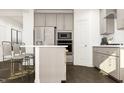 Modern kitchen with gray cabinets, stainless steel appliances, and a breakfast bar with seating at 1004 Red Roses Ave, Durham, NC 27703