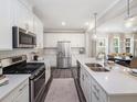 Bright kitchen with stainless steel appliances, white subway tile backsplash, and a view into the dining area at 1005 Red Roses Ave, Durham, NC 27703