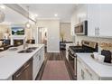 Spacious kitchen featuring stainless steel appliances, white cabinets, quartz counters, and an open floor plan at 1005 Red Roses Ave, Durham, NC 27703