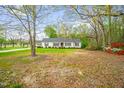 Quaint single-story home nestled on a lush lot with mature trees and vibrant azaleas at 1022 Glover Rd, Dunn, NC 28334