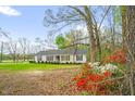 Inviting exterior of a single-story house surrounded by colorful azaleas and mature trees at 1022 Glover Rd, Dunn, NC 28334