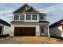 New construction two-story home featuring a two-car garage and black shutters at 104 Fairwinds Dr, Lillington, NC 27546