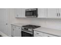 Stainless steel oven range and white patterned backsplash in a modern kitchen at 104 Fairwinds Dr, Lillington, NC 27546