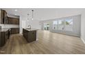 Open-concept kitchen with an island, granite countertops, and dark wood cabinetry with stainless steel appliances at 104 Ripple Way # 318, Clayton, NC 27520