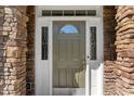 Close-up of an olive green front door with decorative sidelights and a stone surround at 12812 Baybriar Dr, Raleigh, NC 27613