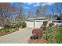 Two-car garage with a wide driveway and attractive landscaping around the base of the building at 1309 Langdon Pl, Pittsboro, NC 27312