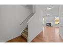 Bright entryway featuring hardwood floors, a staircase, and a glimpse into the open-concept living area at 1445 Lombar St, Raleigh, NC 27610