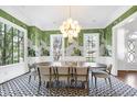 Bright dining room with unique wallpaper, modern chandelier and windows providing ample natural light at 1925 Banbury Rd, Raleigh, NC 27608