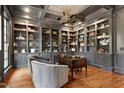 Luxurious home office features extensive built-in shelving, coffered ceiling, and elegant decor at 1925 Banbury Rd, Raleigh, NC 27608
