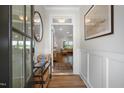 Open entryway leading into a naturally lit living area, featuring wood flooring and elegant wainscoting at 217 Duncan Creek Rd # 124, Lillington, NC 27546