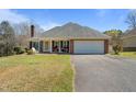 Brick home with attached garage, lawn, and covered front porch with seating at 248 Brookfield Cir, Sanford, NC 27330