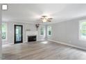 Bright living room with hardwood floors, a modern fireplace, and large windows overlooking the lush backyard at 2812 Dahlgreen Rd, Raleigh, NC 27615