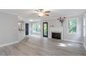 Open living room with gray walls, ceiling fan, fireplace and vinyl floors at 2812 Dahlgreen Rd, Raleigh, NC 27615