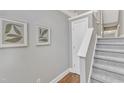 Bright stairway featuring gray walls, hardwood floors, carpeted stairs, and modern decor at 3001 Imperial Oaks Dr, Raleigh, NC 27614