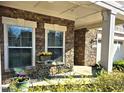 Inviting front porch with stone accents, perfect for relaxing and enjoying the outdoors. Seating area at 3009 Kildaire Dairy Way, Apex, NC 27539