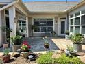 Enclosed patio with multiple sliding windows, adorned with beautiful potted plants at 3009 Kildaire Dairy Way, Apex, NC 27539
