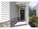 Welcoming front entryway featuring a black door with wreath and decorative stone accents at 3144 Star Gazing Ln, Durham, NC 27703