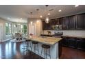 Kitchen island with granite countertops, seating, and stainless steel appliances at 4026 Overcup Oak Ln, Cary, NC 27519