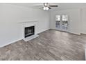 A bright living room features a fireplace, ceiling fan and French doors, showcasing its inviting ambiance at 4507 Lazyriver Dr, Durham, NC 27712