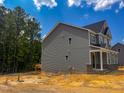 Exterior view of a new construction home from the side, set on a tree-lined lot at 452 Duncan Creek Rd # 156, Lillington, NC 27546