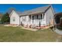 Inviting home with a quaint front porch, manicured lawn, and charming details at 46 Trawick Pl, Clayton, NC 27520