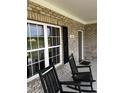 Inviting front porch with two black rocking chairs, a view of the yard, and the house number at 55 Glasgow, Rocky Mount, NC 27804