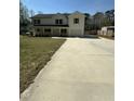 Long driveway and a view of the home's front exterior, featuring a two-car garage and wooden shutters at 6932 Buckhorn Duncan Rd, Holly Springs, NC 27540