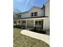 View of front porch with white columns, complementing the home's natural wood shutters and landscaping at 6932 Buckhorn Duncan Rd, Holly Springs, NC 27540