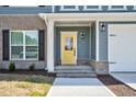 Inviting front entrance with a bright yellow door, classic black hardware, and complementary gray and brick accents at 75 Eltham, Rocky Mount, NC 27804
