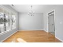 Bright dining room featuring beautiful hardwood floors, a modern chandelier, a large window, and neutral wall color at 7707 Oak Marsh Dr, Raleigh, NC 27616