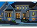 Attractive home entrance featuring stylish multi-lite doors, stone accents, and manicured landscaping at 8005 Woodcross Way, Wake Forest, NC 27587
