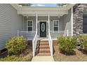 Inviting front porch with brick steps, white railing, and a decorative front door at 808 Cross Link Dr, Angier, NC 27501