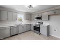 Well-lit kitchen with gray cabinets, stainless steel appliances, and quartz countertops at 8215 S Nc 119 Hwy, Mebane, NC 27302