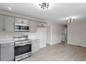 Spacious kitchen featuring gray cabinets, stainless steel appliances, and modern light fixtures at 8215 S Nc 119 Hwy, Mebane, NC 27302