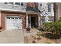 Charming home entrance features a brick facade, a single-car garage, and a quaint landscaped walkway at 106 Madison Square Ln, Cary, NC 27513