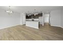 Bright, open living space features hardwood floors and flows into the modern kitchen area with pendant lighting at 108 Ripple Way # 319, Clayton, NC 27520