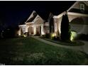 Striking nighttime view of a well-lit home highlighting architectural details and landscaping at 1101 Dovefield Ln, Youngsville, NC 27596