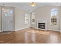 Bright living room with hardwood floors, arched windows, fireplace, and a vaulted ceiling at 1159 Blue Bird Ln, Wake Forest, NC 27587