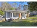 Charming blue-gray home with a welcoming front porch and a well-manicured lawn at 1213 Lincoln St, Durham, NC 27701
