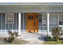 A solid wood front door with glass insets and blue-gray siding at 1213 Lincoln St, Durham, NC 27701