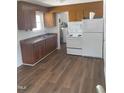 Functional kitchen featuring laminate countertops, flooring, a white fridge, and ample cabinet space at 1314 Hearthside St, Durham, NC 27707