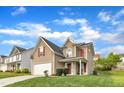 Two-story home with a well-manicured lawn, red shutters, tan siding and an attached garage in a suburban neighborhood at 1320 Rushing Creek Pkwy, Raleigh, NC 27610