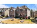 Side view of a brick two-story home with manicured landscaping and a two-car garage at 1624 Pantego Trl, Cary, NC 27519