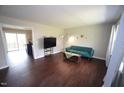 Open-concept living room showcasing hardwood floors, a blue sofa, and seamless access to other areas at 221 Lane Of Tristram, Garner, NC 27529