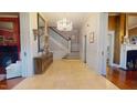 Elegant foyer featuring a grand staircase, chandelier, and tiled floor for a welcoming entrance at 238 N Main St, Wake Forest, NC 27587