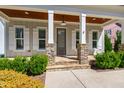 Inviting front porch with stone-clad columns, wood ceiling, and a stylish entry door at 2500 Everett Ave, Raleigh, NC 27607