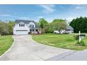 Wide shot of a two-story home with a large front yard and driveway with mature trees at 2709 White Rail Dr, Fuquay Varina, NC 27526